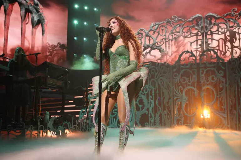 Chappell Roan performing live on stage in a corset and green gloves