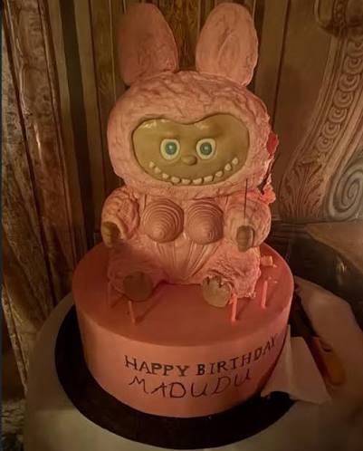 Madonna standing with her custom evil eye birthday cake